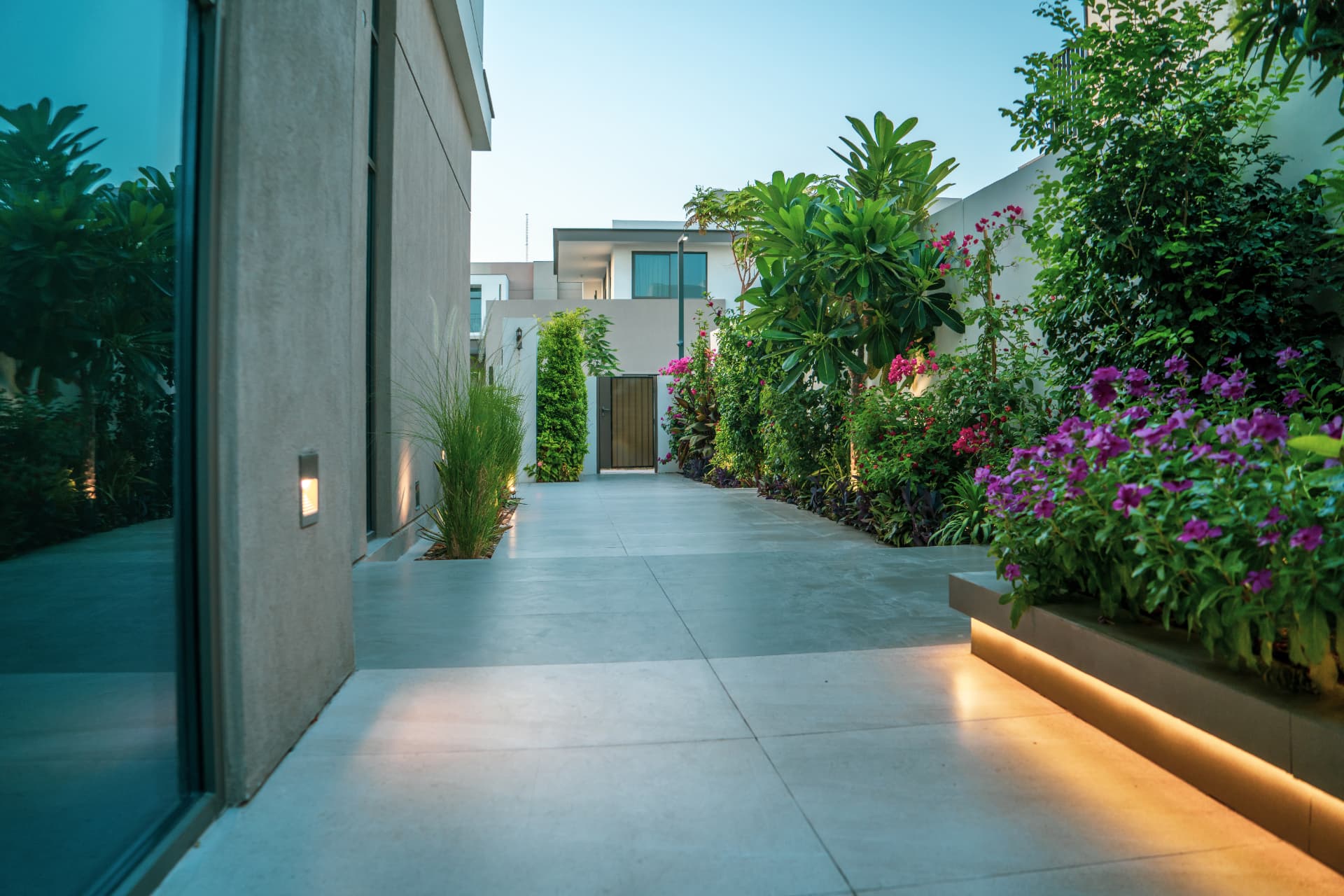 Same style of Dubai villa garden walkway lit in the evening with landscape lighting