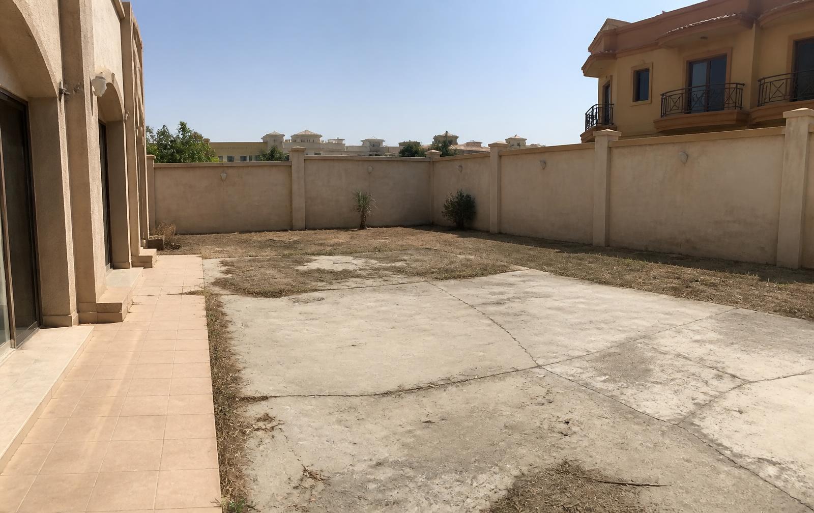 Dubai villa backyard before landscaping, bare concrete and dry ground